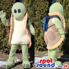 Funny green turtle mascot with a blue rucksack on the back -