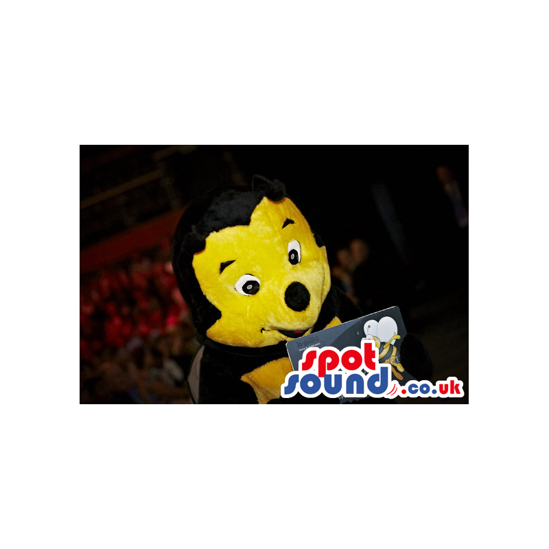 Delighted looking black and yellow bee mascot with antennae -
