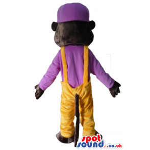 Brown monkey wearing yellow trousers and a purple t-shirt and