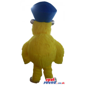 Yellow furry monster with a light blue nose wearing dark