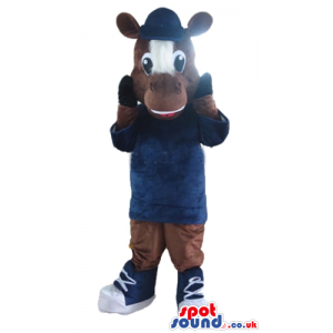 Brown cow with a brown and white face wearing a blue sweater
