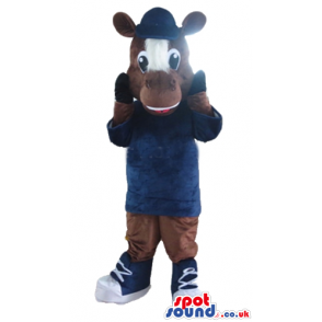 Brown cow with a brown and white face wearing a blue sweater