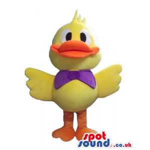 Yellow duck with orange beak and legs wearing a purple bow tie