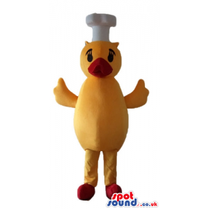 Yellow chicken with a red beak and feet wearing a chef's hat -