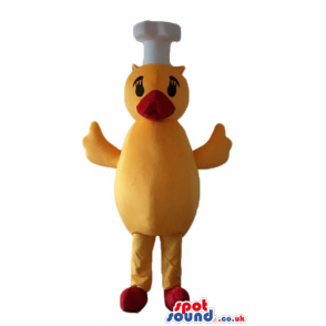 Yellow chicken with a red beak and feet wearing a chef's hat -