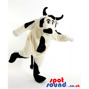 Big white cow mascot with black dapples and pair of horns -