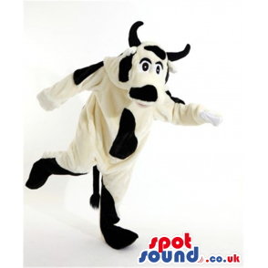 Big white cow mascot with black dapples and pair of horns -