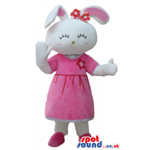 White rabbit with pink ears wearing a red flower on the head, a