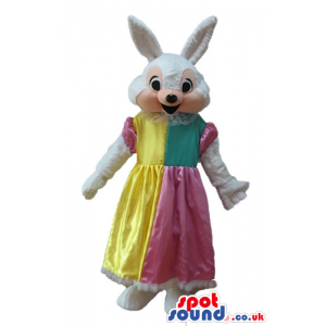 White rabbit wearing a long yellow, pink and green dress -