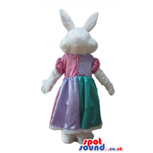 White rabbit wearing a long yellow, pink and green dress -