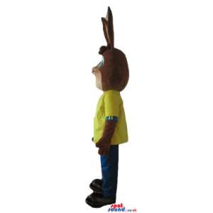 Brown rabbit wearing a yellow t-shirt and blue trousers -