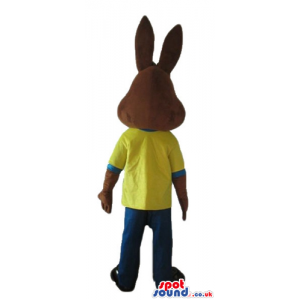 Brown rabbit wearing a yellow t-shirt and blue trousers -