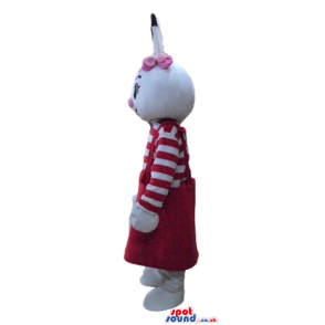 White rabbit with pink and black ears wearing a striped red and