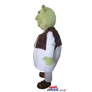 Green ogre wearing a white tunic and a brown furry vest -