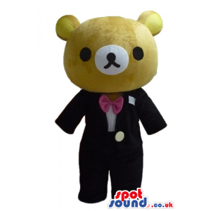 Brown bear wearing a black suit a white shirt and pink bow tie