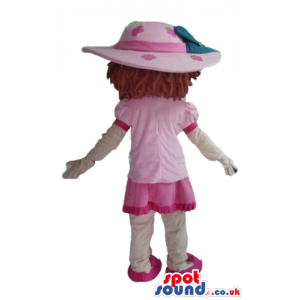 Brown-haired girl wearing a pink hat, a pink dress, white socks