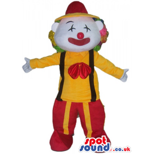 Clown with multicolored hair and a red nowse wearing a yellow