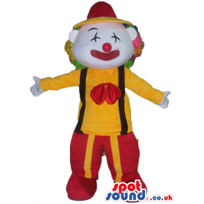 Clown with multicolored hair and a red nowse wearing a yellow