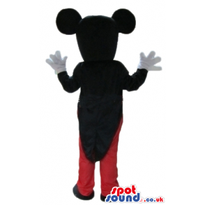 Mickey mouse wearing a black jacket red trousers, a white shirt