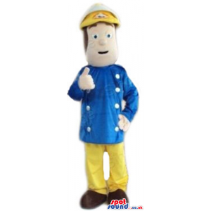 Man wearing a sailor hat, a blue jacket, yellow trousers and