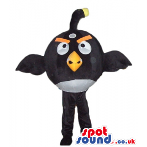 Black angry bird with thick orange eyebrows and a yellow beak -