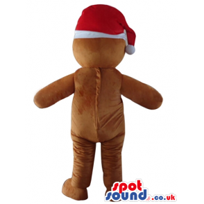 Ginger bread man wearing a santa claus hat and a red vest with