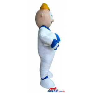 Blond man wearing a white suit with details in blue and a