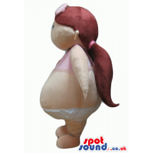 Girl with brown pony tails wearing white diapers and a pink