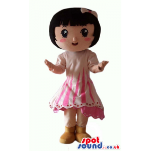 Smiling girl with short black hair wearing a pink dress and