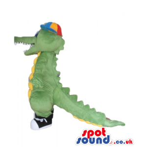 Green alligator with a yellow belly wearing black trainers and