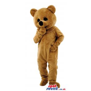 Brown teddy bear mascot thinking putting his hand in his mouth