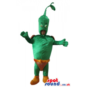Green vegetable with small eyes wearing brown trunks and orange