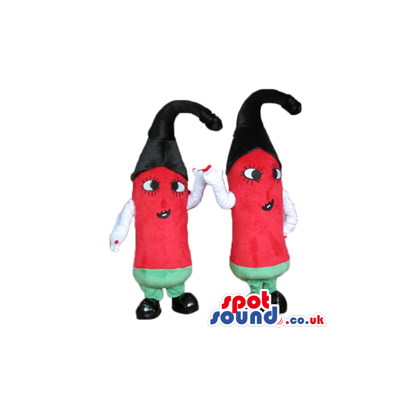 2 red peppers with big eyes, a black hat, green trousers, white