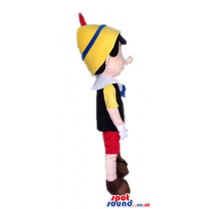 Pinnochio wearing red trousers, a yellow shirt, a black vest, a