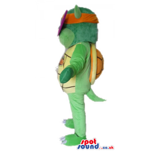 Green turtle with a yellow belly wearing an orange and purple