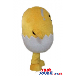 Yellow chicken with small black eyes and a huge smile hatching