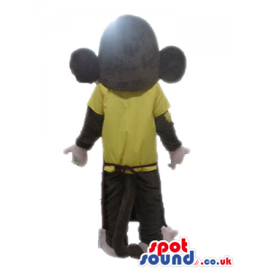 Brown monkey with a big head and big ears wearing a yellow