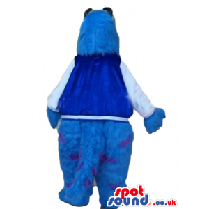 Blue furry monster with brown horns and claws and violet dots -