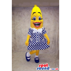 Banana Fruit Mascot Wearing A Polka Dot Dress In Blue And White