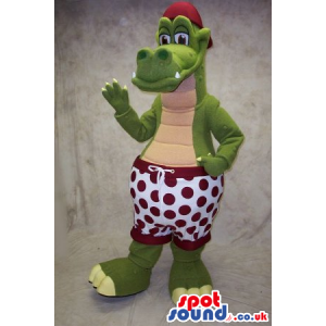 Green Dragon Mascot Wearing A Red Cap And Shorts With Dots -