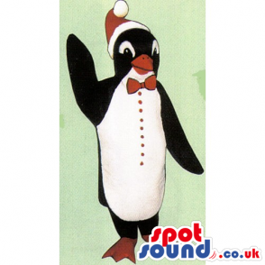 Cute Penguin Mascot Wearing A Christmas Hat And A Bow Tie -