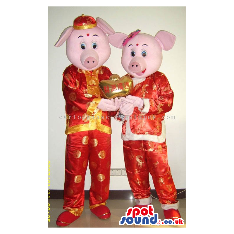 Pig Couple Mascots Wearing Red And Golden Oriental Clothes -