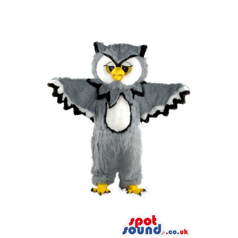 Furry owl mascot with a his wings wide spread and standing -