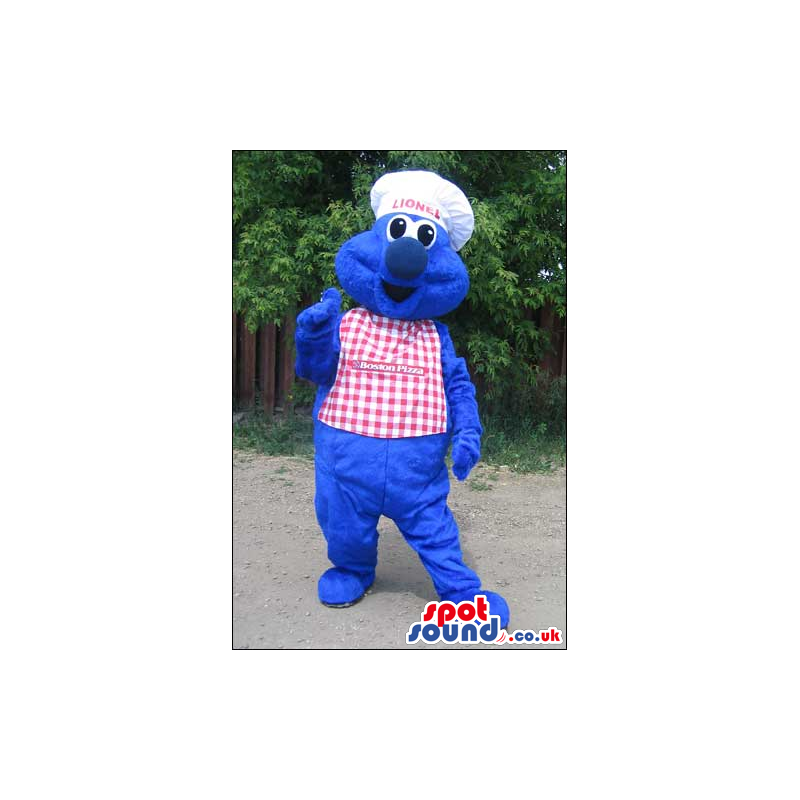 Blue Monster Mascot Wearing A Checked Apron And A Chef Hat -