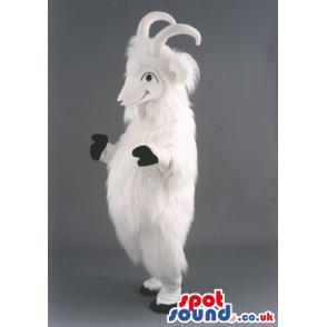White furry goat mascot with two horns standing and smiling -