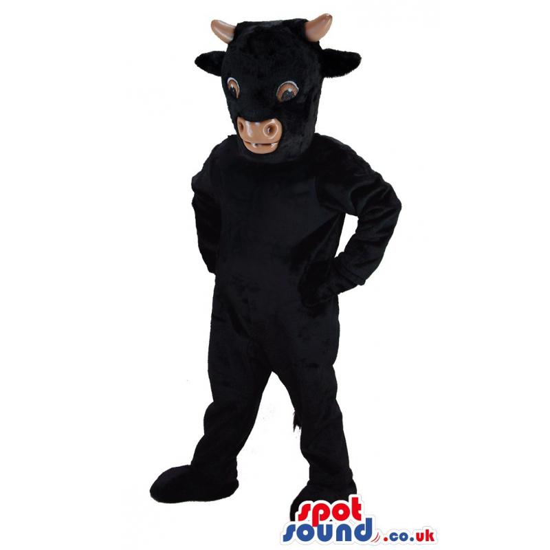 Black cow mascot standing and keeping his hands on waist -