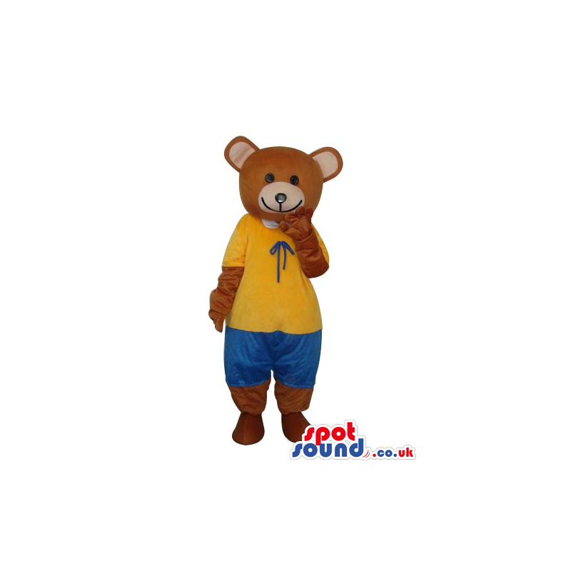 Brown Teddy Bear Mascot Wearing A Yellow Shirt And Blue Pants -