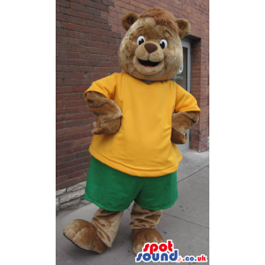 Brwon Bear Plush Mascot Wearing A Yellow T-Shirt And Shorts -