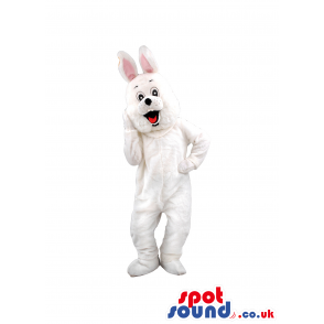 White smiling bunny mascot with pink pointy ears standing up -