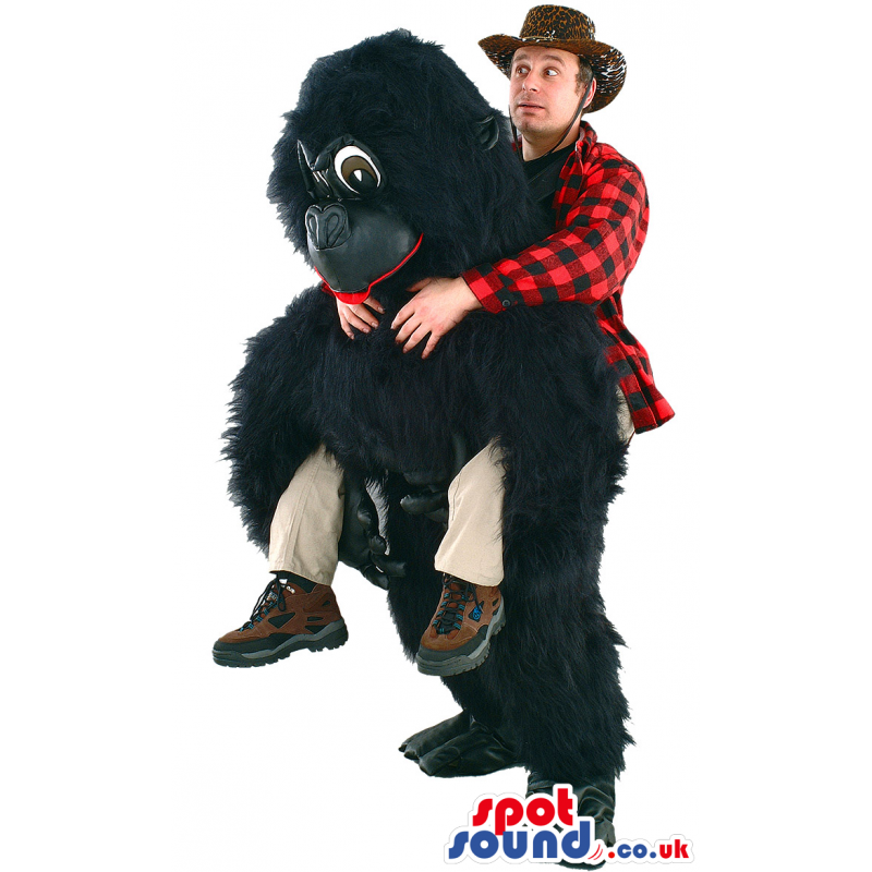 Giant black gorilla mascot with dark eyes and red tongue -